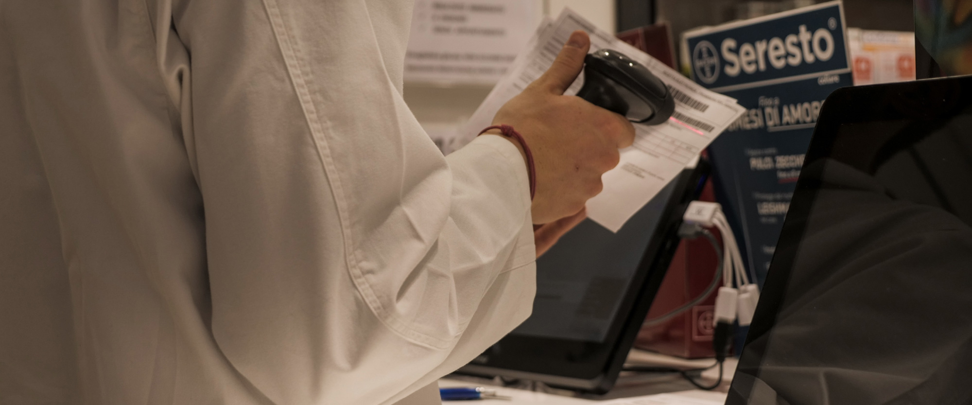 Dettaglio del servizio al banco della Farmacia Corvi di Piacenza, con lettura del codice a barre