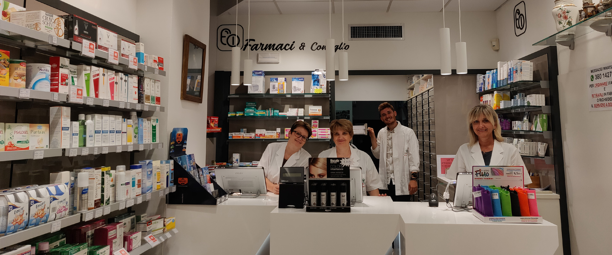 Interno della Farmacia Corvi di Piacenza con il personale al banco